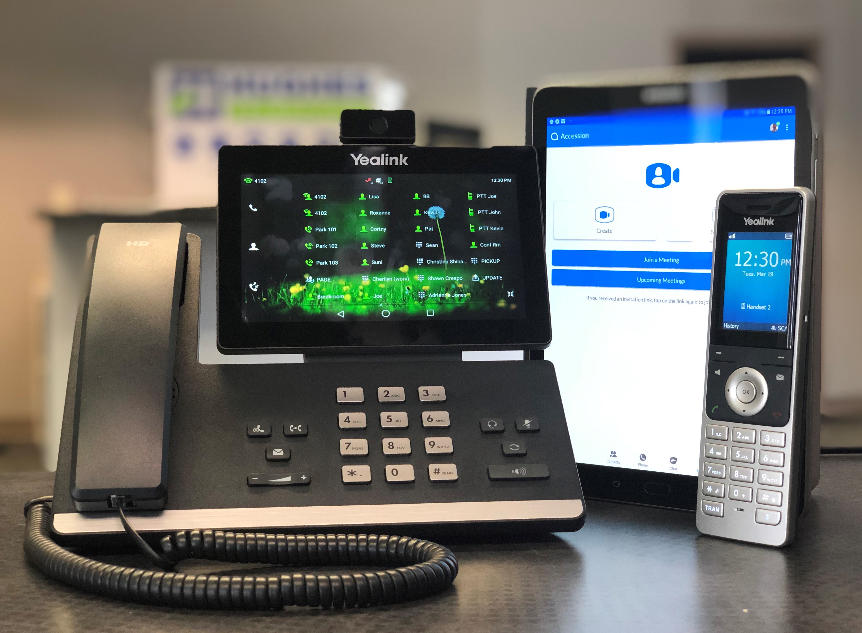 A Yealink phone set, tablet and cordless phone.